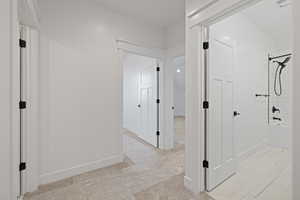 Hall featuring baseboards and light colored carpet