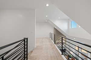 Hall with light colored carpet, an upstairs landing, and recessed lighting