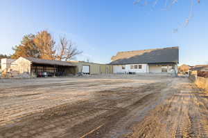 Back of house featuring an outbuilding, a patio, an outdoor structure, and a barn/carport