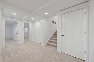 Stairs into basement with bedrooms on one side and family room in the other direction