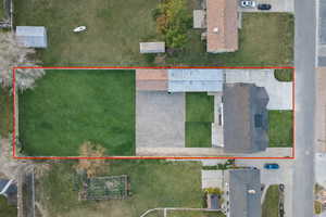 Aerial view of property and surrounding area featuring property boundaries highlighted. Grassed and gravel areas are AI-generated.