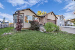 View of front of property with brick siding, a garage, and concrete driveway
