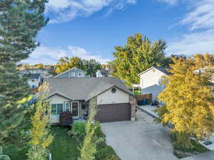 View of front of property featuring concrete driveway, brick siding, a garage, and roof with shingles