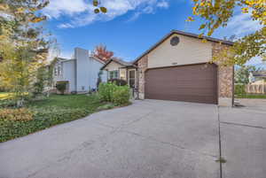 View of front of house featuring driveway and brick siding