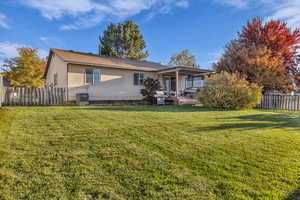 Rear view of house featuring a fenced backyard and a deck
