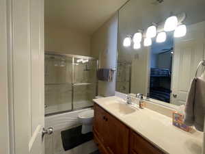 bathroom #2 the vanity, enclosed tub / shower combo, and tile patterned floors