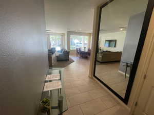 Corridor with light tile patterned floors and a textured wall
