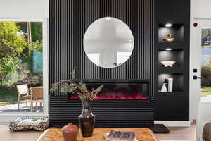 Detailed view of built in shelves, wood finished floors, and a glass covered fireplace