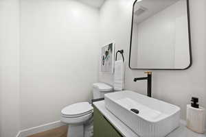 Half bathroom with baseboards and vanity