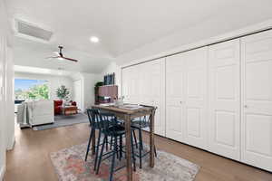 Dining space featuring wood finished floors, lofted ceiling, ceiling fan, attic access, and recessed lighting
