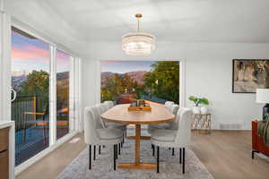 Dining room with a mountain view, light wood-style floors, and a chandelier