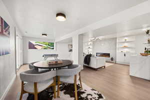 Dining area with a fireplace, light wood-style flooring, and built in features