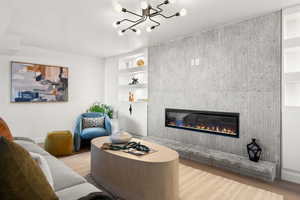 Living room featuring built in features, a tile fireplace, and wood finished floors