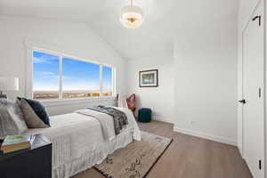 Bedroom featuring lofted ceiling and light wood-style flooring