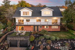 Back of property with a balcony, outdoor dining area, and a shingled roof