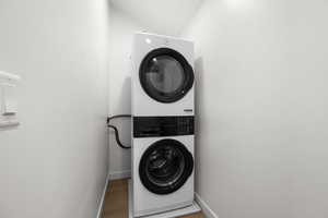 Washroom featuring baseboards and stacked washer / dryer