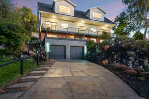 View of front facade featuring a balcony, concrete driveway, and a garage