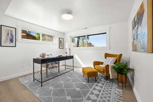 Office space featuring healthy amount of natural light, a textured ceiling, and light wood-style floors