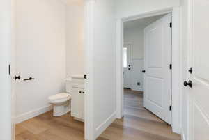 Half bath featuring light wood finished floors and vanity