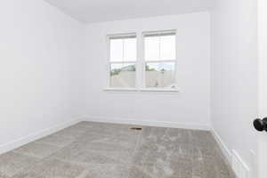 Empty room featuring carpet flooring and baseboards