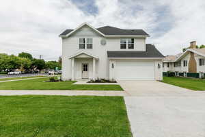 View of front of house with a front yard, driveway, a garage, and a shingled roof