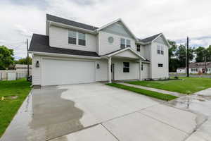 View of front of property with concrete driveway, an attached garage, roof with shingles, and a porch