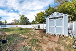 Fenced backyard with a storage shed and a trampoline