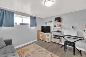 Living area featuring light wood-style floors and a textured ceiling