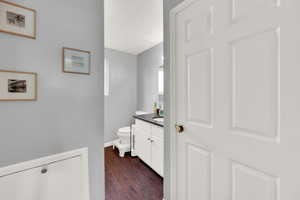 Half bath with vanity and dark wood-style flooring