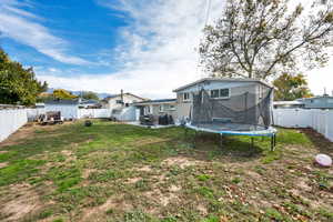 Fenced backyard with a patio and a trampoline