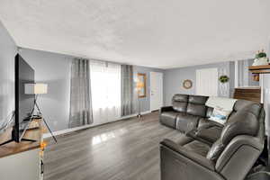 Living room featuring a textured ceiling and wood finished floors