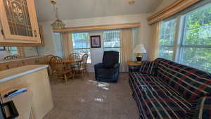 Living area featuring light carpet and vaulted ceiling