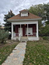 Bungalow with covered porch and a front lawn