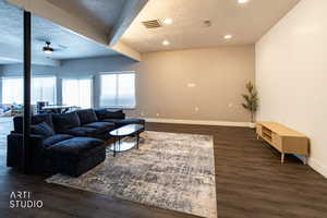 Living room featuring a textured ceiling, beamed ceiling, a ceiling fan, dark wood finished floors, and recessed lighting