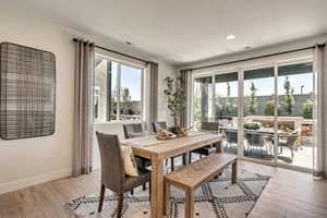 Dining area with light wood-type flooring, plenty of natural light, and recessed lighting