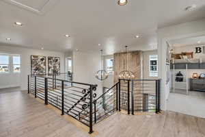 Corridor featuring an upstairs landing, recessed lighting, light wood finished floors, and a chandelier
