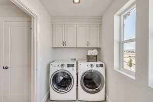 Laundry area featuring cabinet space and separate washer and dryer