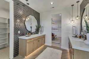 Bathroom featuring recessed lighting, two vanities, light wood-style flooring, a chandelier, and a spacious closet