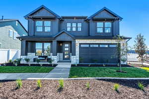 Farmhouse-style home with board and batten siding, stone siding, and an attached garage