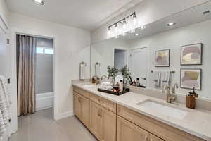 Bathroom featuring double vanity, recessed lighting, and light tile patterned floors
