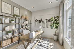 Den area with light wood finished floors and recessed lighting