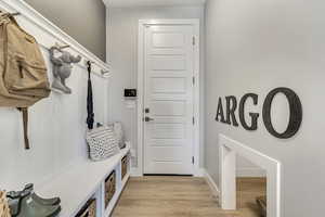 Mudroom with light wood-style floors and baseboards