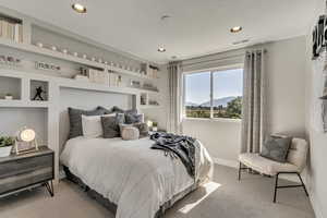 Carpeted bedroom with a mountain view and recessed lighting