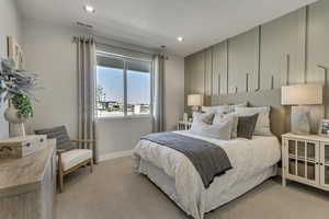 Bedroom featuring light colored carpet and recessed lighting. Not pictured is bathroom en suite.