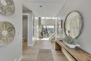 Hall with a chandelier, light wood-type flooring, recessed lighting, and stairs
