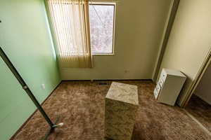 Unfurnished room with dark carpet and a textured wall