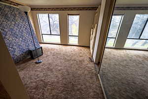 Unfurnished living room featuring dark colored carpet