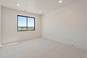 Spare room with light colored carpet and recessed lighting