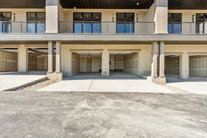 Back of house with an attached garage, driveway, and stucco siding