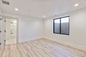 Spare room with light wood finished floors and recessed lighting